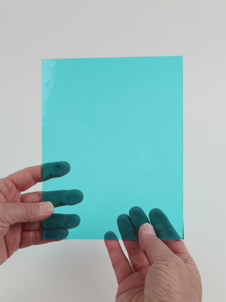 Video of the Aqua Transparent glass plate in transparent blue, 15x19cm, held up and tilted to show its pattern and transparency