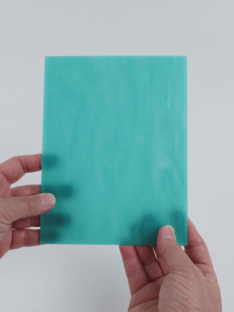 Video of the Pale Waterfall glass plate in translucent turquoise, 15x19cm, held up and tilted to show its pattern and transparency