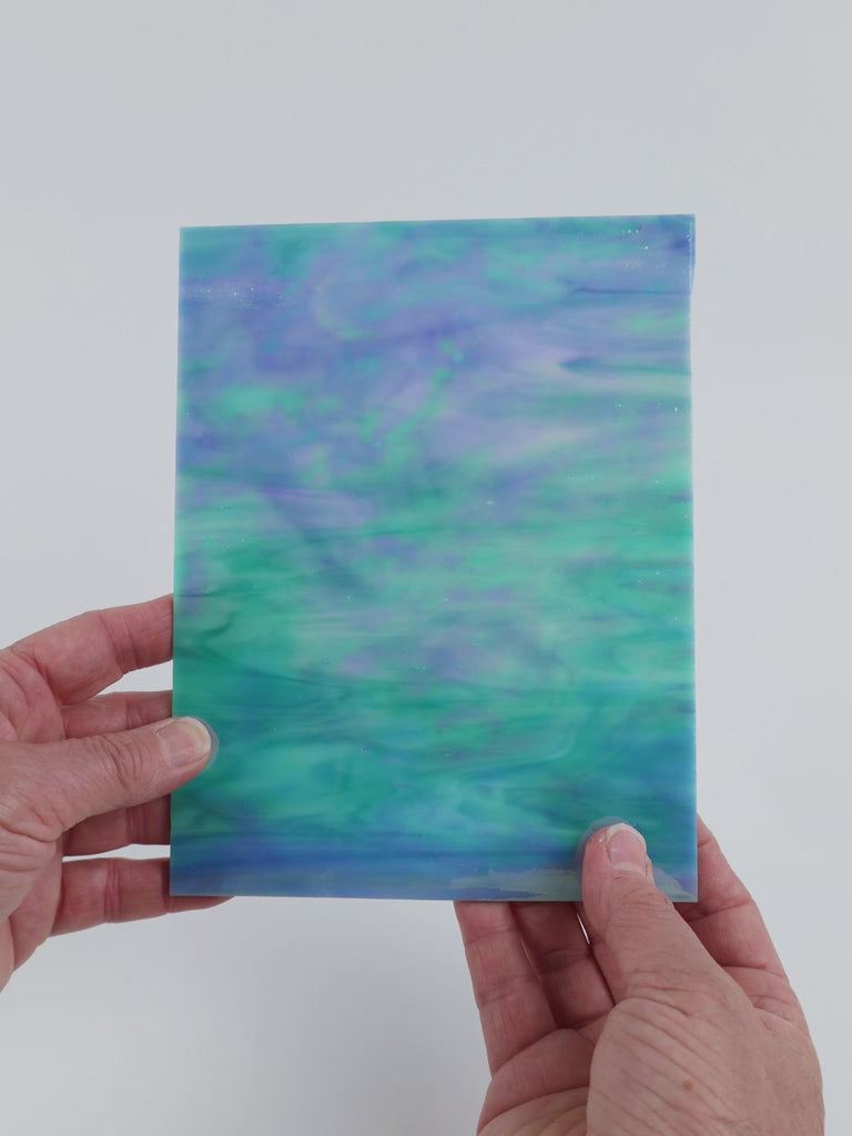 Video of the Soft Aqua Pearl glass plate in iridised translucent blue, 15x19cm, held up and tilted to show its pattern and transparency