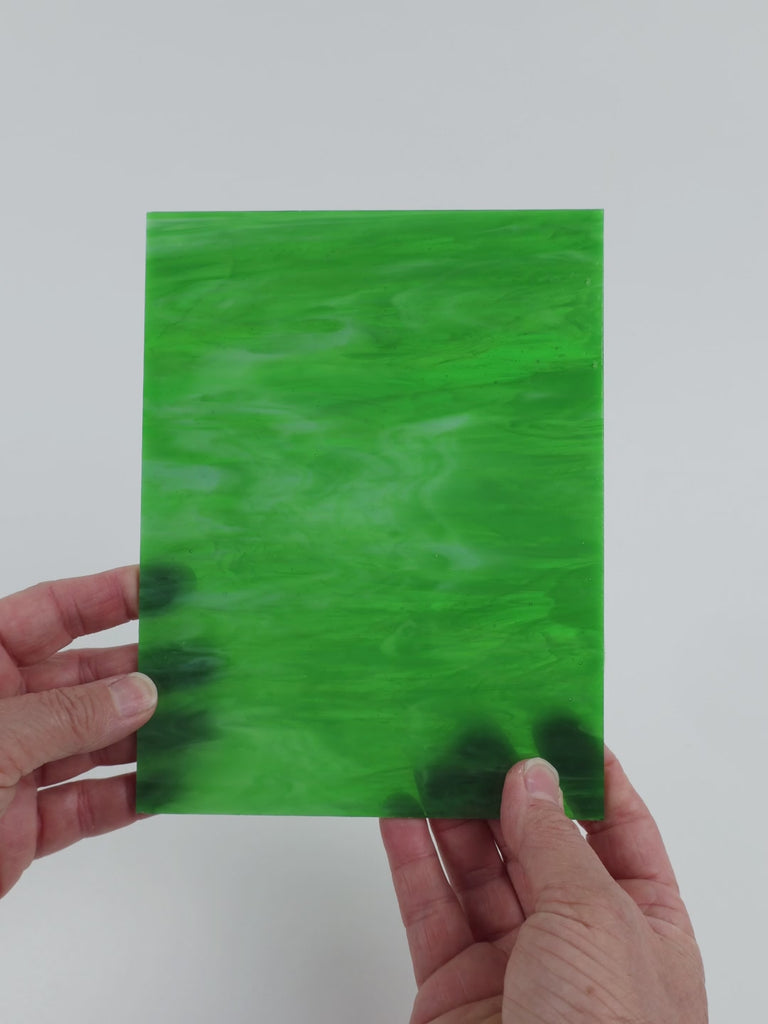Video of the Fern Wispy glass plate in translucent green, 15x19cm, held up and tilted to show its pattern and transparency
