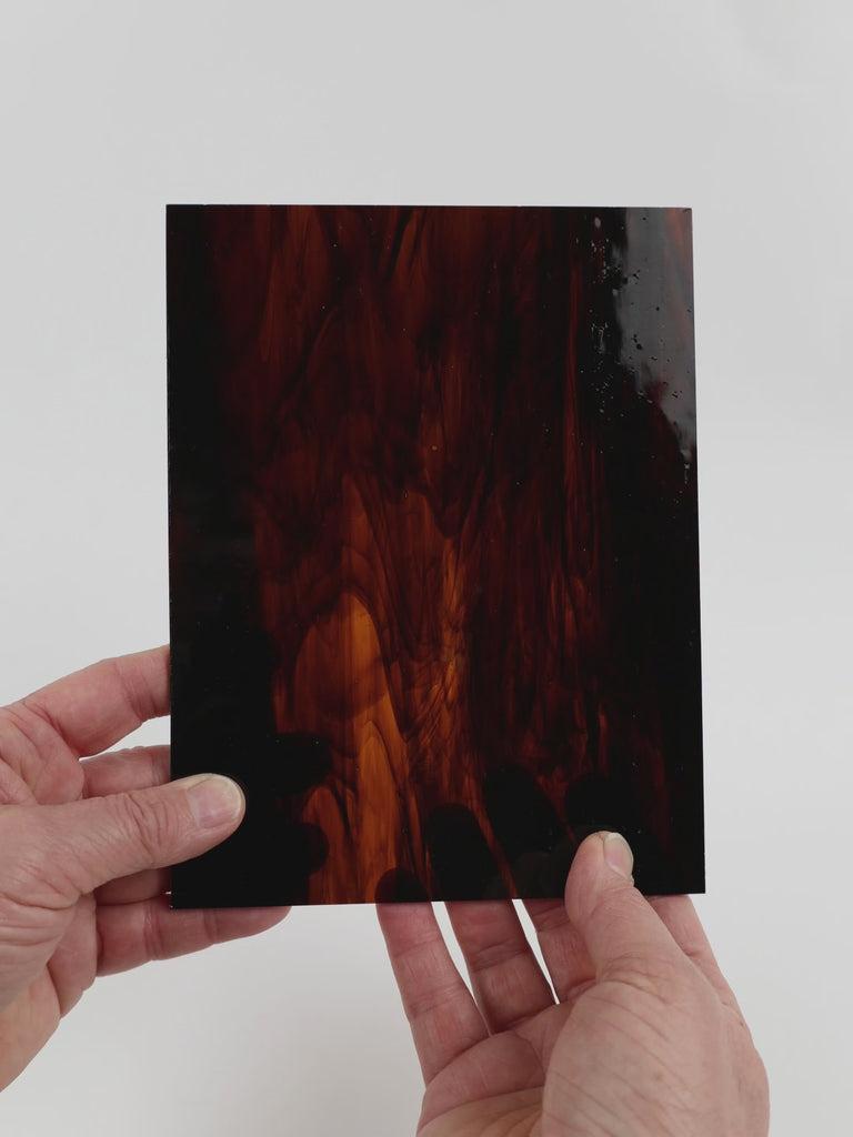 Video of the Beach glass plate in semitransparant brown, 15x19cm, held up and tilted to show its pattern and transparency