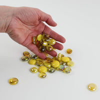 Video of yellow mix glass nuggets in lemon, golden and amber shades with an iridescent sheen, 16–20 mm, picked up from a pile by hand and dropped back to show their size, round shape and shine