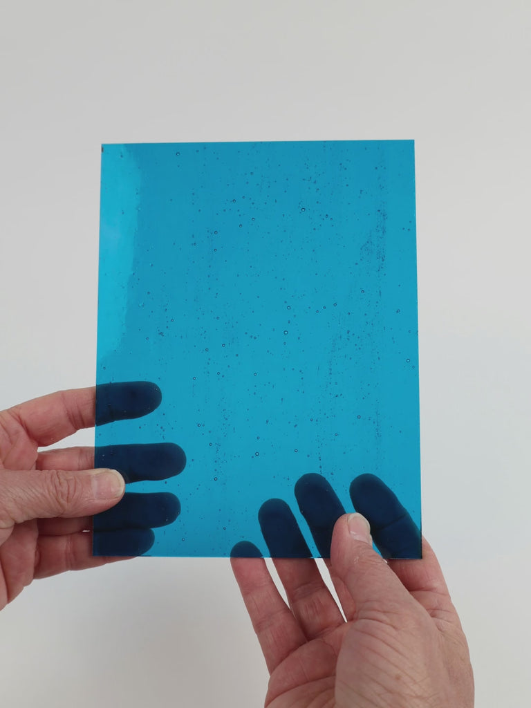 Video of the Clear Turquoise glass plate in transparent turquoise, 15x19cm, held up and tilted to show its pattern and transparency